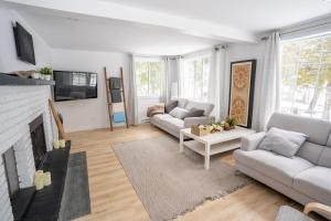 sala de estar con 2 sofás y chimenea en Bright Amazing 6 Bed Chalet Waterfront in Rigaud en Rigaud