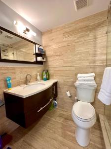West Bay的住宿－Seven Mile View Condo 3A，一间带卫生间、水槽和镜子的浴室
