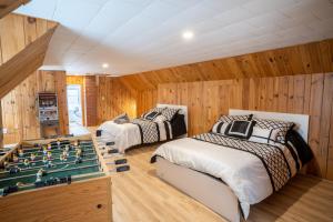 a room with two beds and a pool table at Bright Amazing 6 Bed Chalet Waterfront in Rigaud in Rigaud