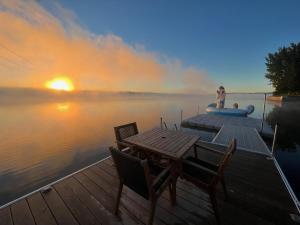 a person sitting on a raft on a dock on a lake at Bright Amazing 6 Bed Chalet Waterfront in Rigaud in Rigaud