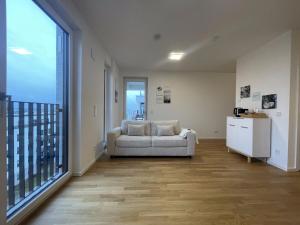 a living room with a couch and a large window at Luxurious and stylish apartment at BER Airport in Schönefeld