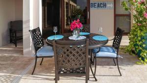 stół z krzesłami i wazon kwiatów na nim w obiekcie Seven Mile View Condo 3A w mieście West Bay