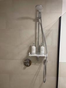 a shower with two soap bottles on a shelf at Luxurious and stylish apartment at BER Airport in Schönefeld