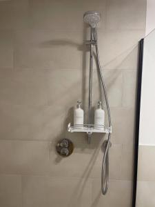 a shower with two soap bottles on a shelf at Luxurious and stylish apartment at BER Airport in Schönefeld +25 photos