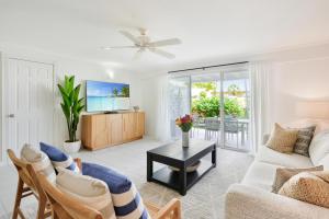 un soggiorno con divano e tavolo di Coconut Bay Villas #113 a George Town
