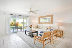 uma sala de estar com um sofá e uma mesa em Coconut Bay Villas #113 em George Town