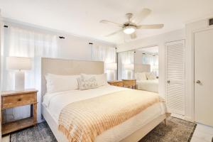 a white bedroom with a bed and a ceiling fan at Coconut Bay Villas #113 in George Town