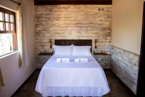 una camera da letto con un letto con due candele sopra di Encanto Paraty Beach a Parati