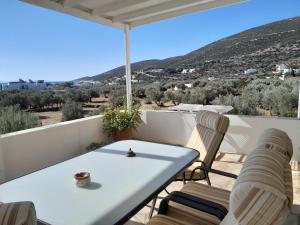 una mesa y sillas en un balcón con vistas en Villa Simeon en Platís Yialós Sifnos
