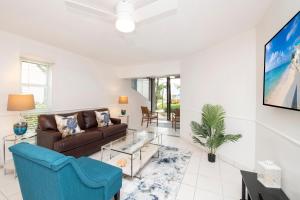 a living room with a couch and a tv at Cayman Reef Resort #52 in George Town