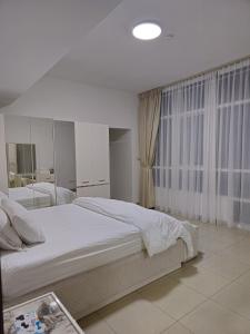 a bedroom with a large bed and a large window at Luxury Apartment - Beach Tower 2 in Sharjah