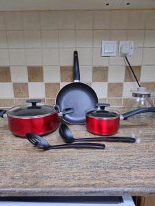 three pots and pans sitting on a kitchen counter at Luxury Apartment - Beach Tower 2 in Sharjah