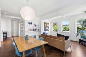 een woonkamer met een bank en een tafel bij Sunlit and Spacious Apt in the Heart of the East in Sydney