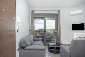a living room with a couch and a chair at E&A luxury apartment with sea view in Rhodes Town