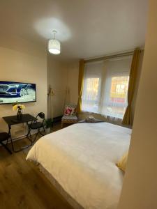 a bedroom with a large white bed and a desk at AlphaStudio-Leeds-Walk 2-City-Centre-FreePark-Wifi in Leeds
