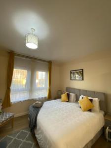 a bedroom with a large bed with yellow pillows at AlphaStudio-Leeds-Walk 2-City-Centre-FreePark-Wifi in Leeds