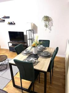 een houten tafel met groene stoelen en een eetkamer bij Charmant Appartement à Metz in Metz