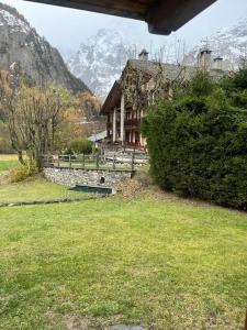 a house in a field with mountains in the background at Jack's House in Courmayeur
