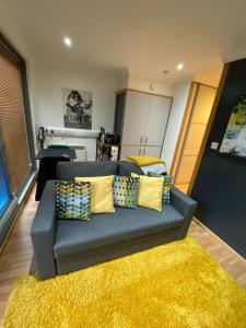a blue couch with yellow pillows in a living room at Chic Citispace -1-Bed Apartment Leeds City-WiFi in Leeds