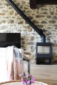 a living room with a stone wall with a fireplace at RUSTIC HOMES in San Vicente de la Barquera
