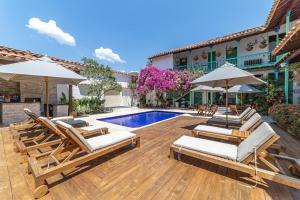 una piscina con sillas y sombrillas junto a un edificio en Casa Cedrela Hotel Boutique, en Jericó