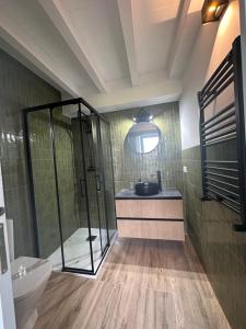uma casa de banho com um chuveiro, um lavatório e um WC. em RUSTIC HOMES em San Vicente de la Barquera
