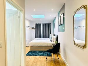 a bedroom with a bed and a mirror and a chair at SeaView Apartment with Roof Terrace and Pool Table in Kent