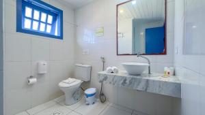 a white bathroom with a sink and a toilet at Pousada Vila Capri in Búzios