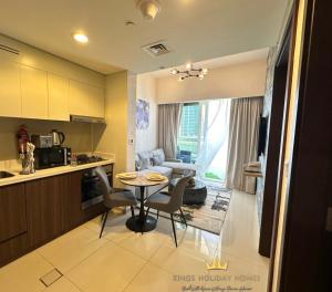 Il comprend une cuisine et un salon avec une table et des chaises. dans l'établissement Reva residence suite burj Khalifa view ,Kings, à Dubaï