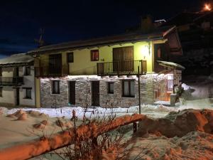 uma casa na neve à noite em BAITA ARIANNA - BILOCALE MOTTA em Sestriere