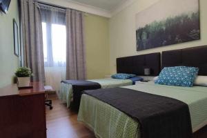 Cette chambre comprend 2 lits et une fenêtre. dans l'établissement FlipHouse Rooms Pensión, à Bilbao
