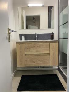 La salle de bains est pourvue d'un lavabo et d'un miroir. dans l'établissement T3 Moderne avec balcon terrasse et parking gratuit, à Niort