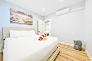 ein Schlafzimmer mit einem großen weißen Bett in einem Zimmer in der Unterkunft Cozy 3 Bedroom Across from Playground on the Beach in Newport Beach