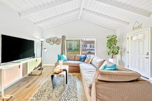 ein Wohnzimmer mit einem Sofa und einem Flachbild-TV in der Unterkunft Cozy 3 Bedroom Across from Playground on the Beach in Newport Beach