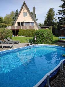 a large blue swimming pool in front of a house at Holiday home in Svahova/Erzgebirge 1694 in Svahová