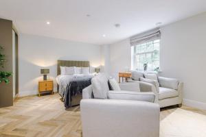 a bedroom with a bed and a couch and chairs at Rock Mill - Stunning Studio Apartment in Stoney Middleton