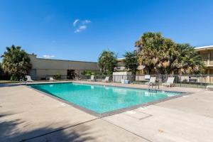 a large swimming pool with chairs and a building at Eco-Inn Suites Baytown in Baytown