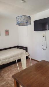a room with a bed and a table and a tv at Lo de tungo in Paraná