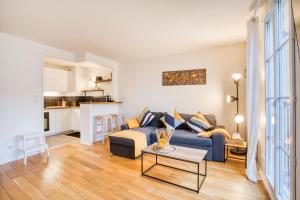 ein Wohnzimmer mit einem blauen Sofa und einem Tisch in der Unterkunft La Serrisienne 4 - Val d'Europe - Disneyland Paris - 6 à 8 Personnes in Serris