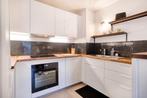 eine weiße Küche mit weißen Schränken und einer Spüle in der Unterkunft La Serrisienne 4 - Val d'Europe - Disneyland Paris - 6 à 8 Personnes in Serris