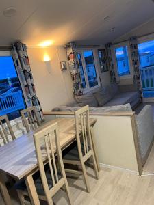 a dining room and living room with a table and chairs at Cjs family caravans in Ayr
