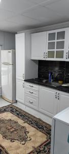 uma cozinha com armários brancos e um frigorífico branco em Mercan Villa em Sapanca