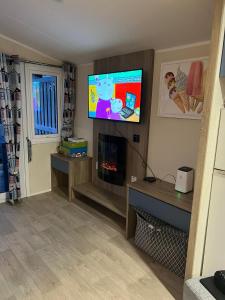 a living room with a tv and a fireplace at Cjs family caravans in Ayr