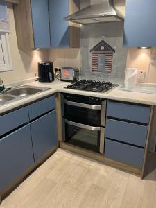 a kitchen with a stove and a sink at Cjs family caravans in Ayr