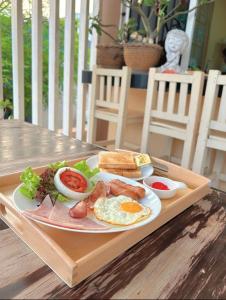 ラン島にあるBLUE OCEAN kohlarn resortの木製テーブルの朝食用の皿
