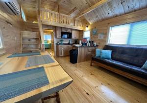 een woonkamer met een bank en een tafel in een hut bij Rustic Cabin with loft in Surf City with Parking in Surf City