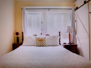 a bedroom with a white bed with a window at Arroyo Vista Inn in Los Angeles