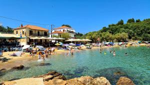 eine Gruppe von Menschen im Wasser an einem Strand in der Unterkunft Katigiorgis Bungalow Villa & SPA in Agios Georgios