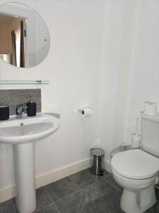 een witte badkamer met een toilet en een wastafel bij Modern and Cosy 1 bedroom Apartment Close to Stadiums, Transport links, Free Parking in Manchester