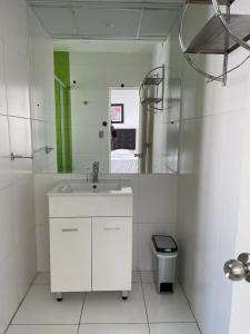 a white bathroom with a sink and a mirror at Lima HOUSE MILANI in Lima